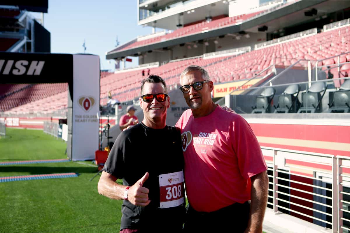 A runner poses for a photo with Tom Rathman.