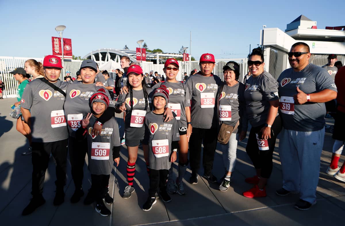 A large group of family and friends pose for a pre-race photo.
