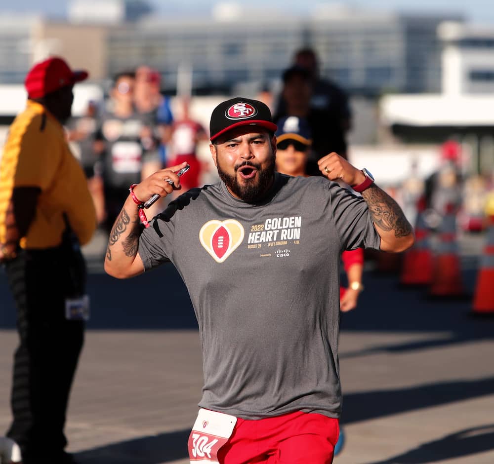 A runner flexes and cheers to the camera in celebration of his performance.