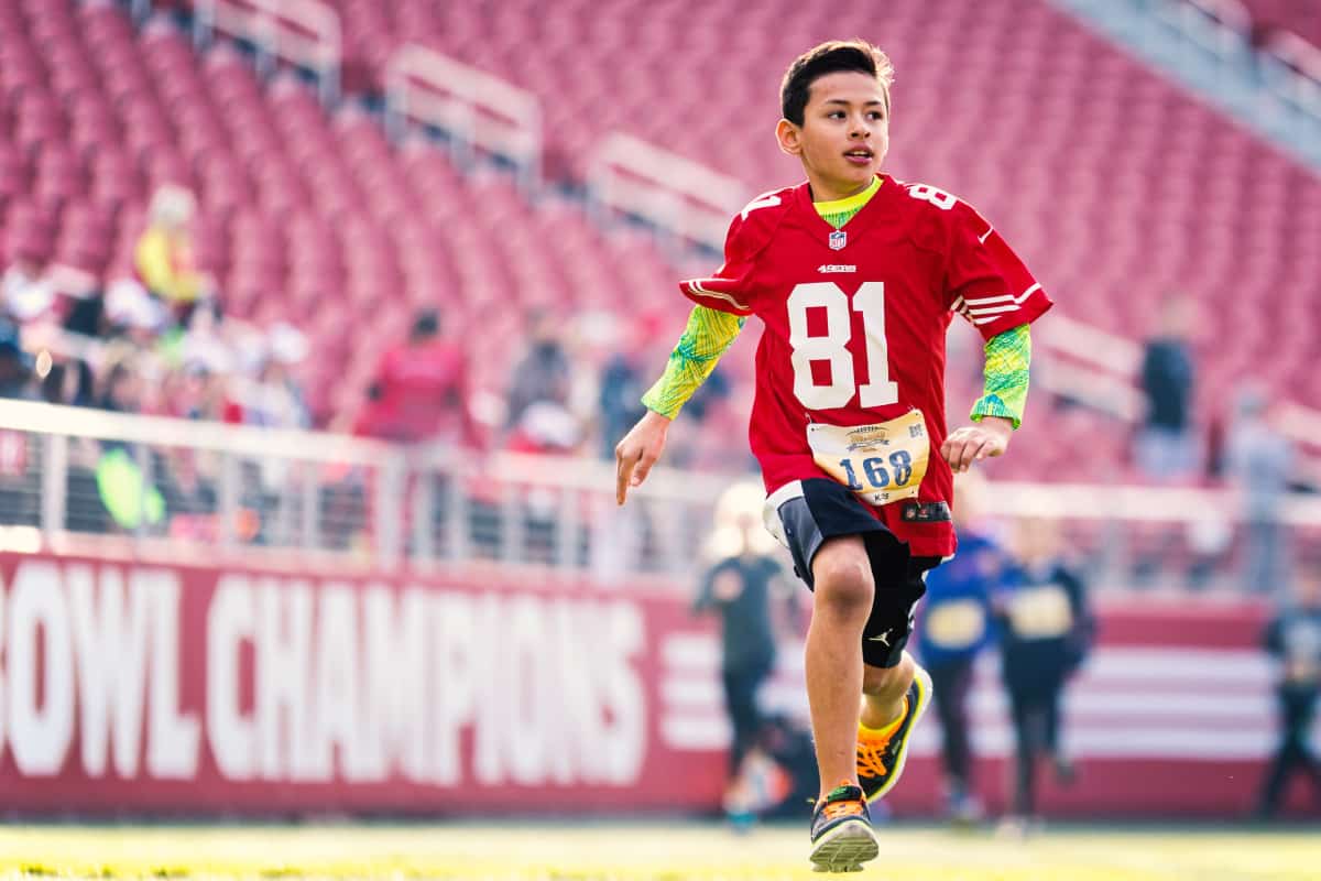 A young fan approaches the finish line on the Levi's Stadium field.