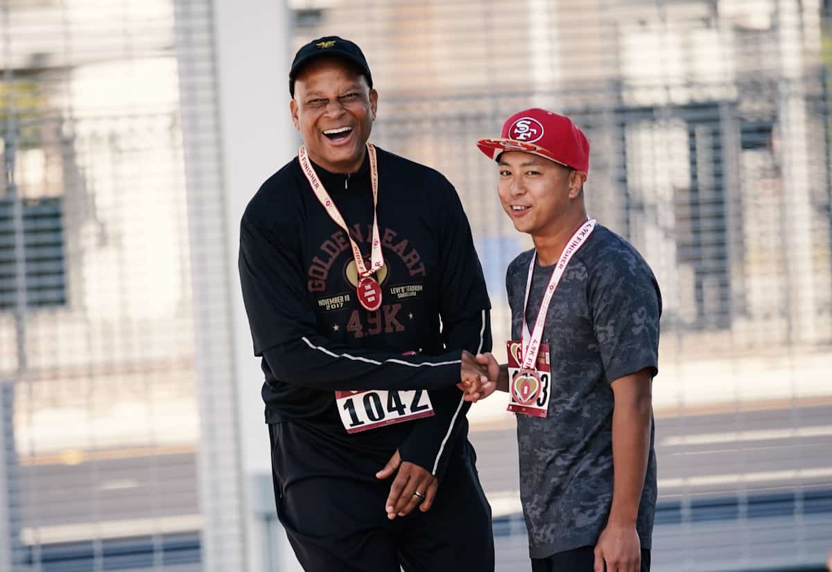 Ronnie Lott shakes the hand of an excited fan after they run together in the 2019 Golden Heart Run.